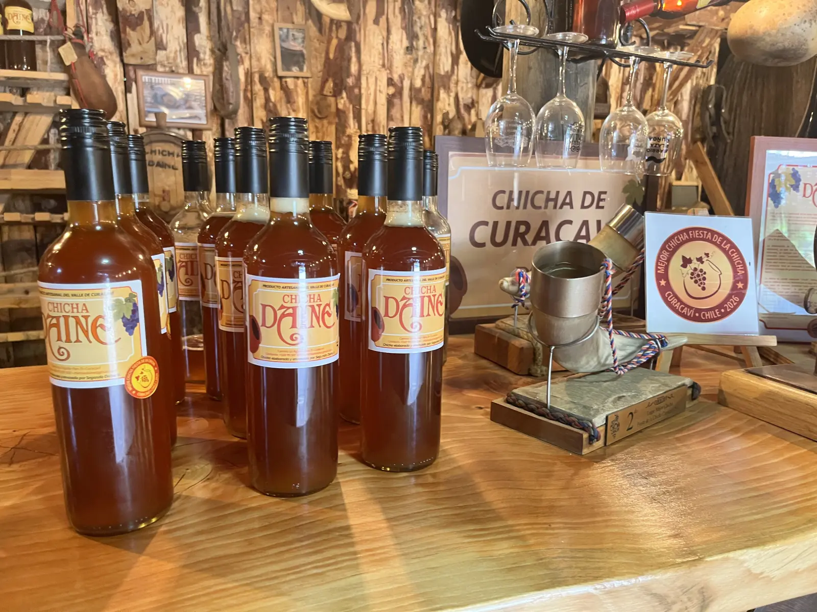 Botellas de Chicha Daine, producto artesanal del valle de Curacaví, sobre el mesón del local